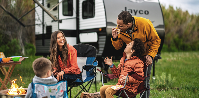 Family camping near camp fire with Jayco travel trailer